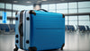 An elegant blue suitcase positioned on the airport terminal floor.